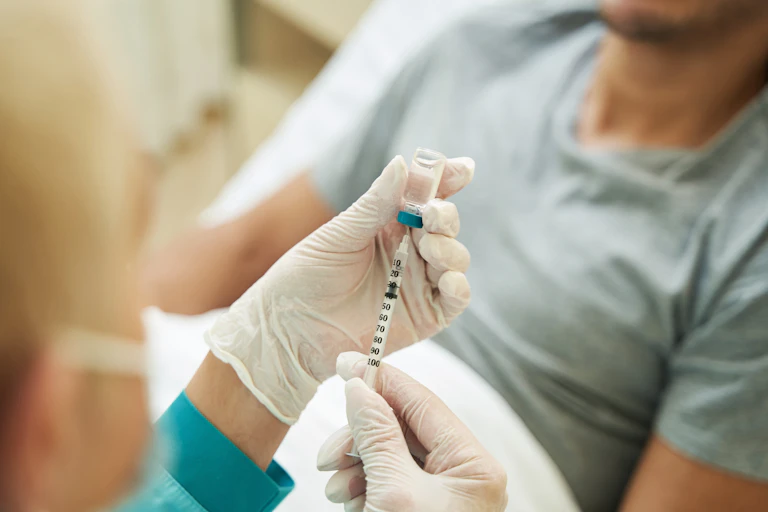 A health-care worker's hands drawing up a vaccine.