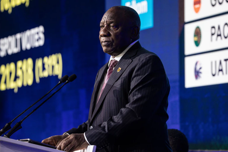 A man in a suit at a podium with microphones