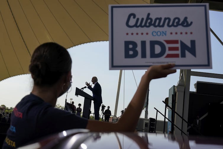 A woman holds up a sign that reads