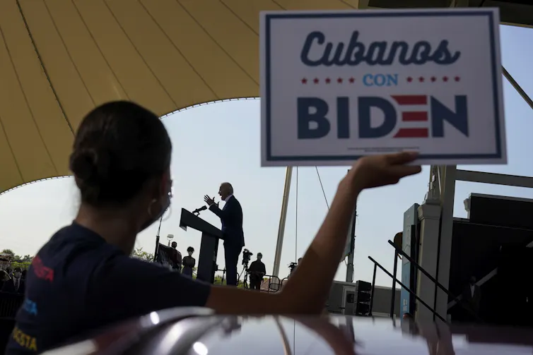 A woman holds up a sign that reads