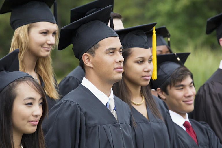 College students don black graduation caps and gowns.