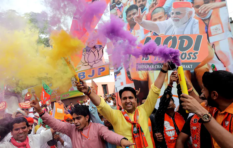 Crowds celebrate with Modi placards.