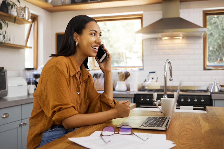 woman on the phone and working at a laptop