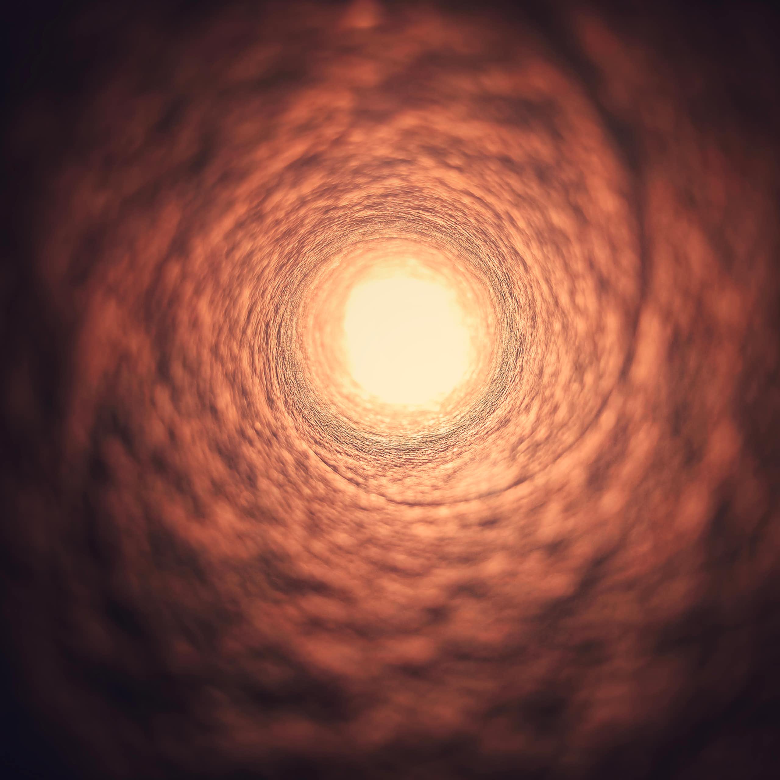 Flesh-colored, textured tunnel funnelling to a circle of light