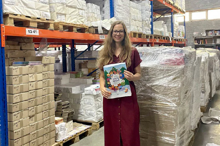 Ukrainian author Kateryna Yegorushkina holds up a copy of her book in a warehouse at FaktorDruk printworks in Kharkiv Ukraine