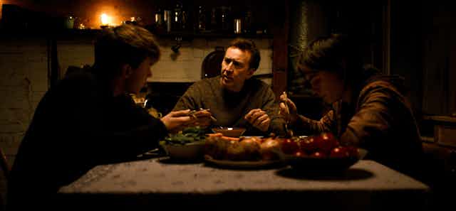 Maxwell Jenkins, Nicolas Cage, and Jaeden Martell sit around a farmhouse dinner table.