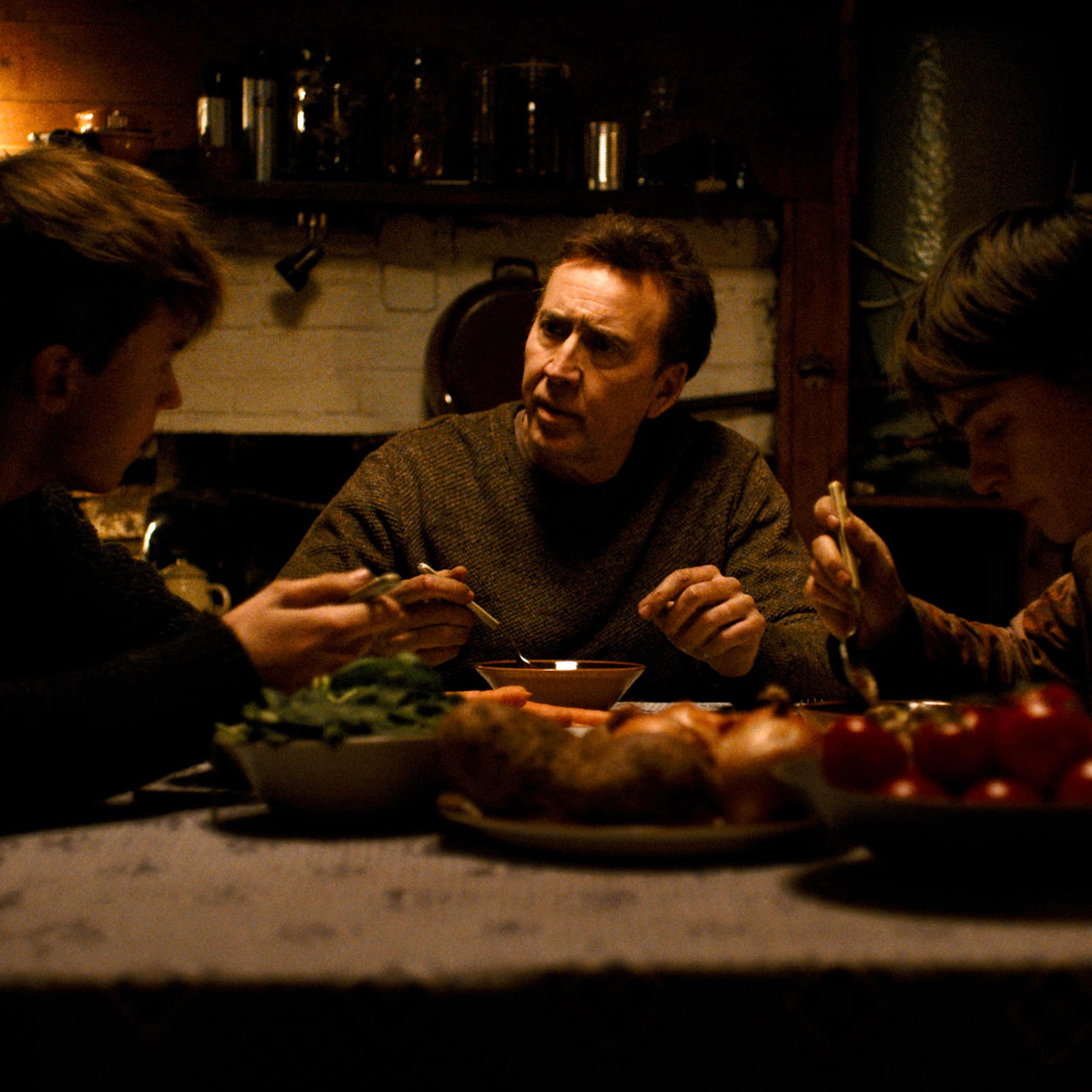 Maxwell Jenkins, Nicolas Cage, and Jaeden Martell sit around a farmhouse dinner table.