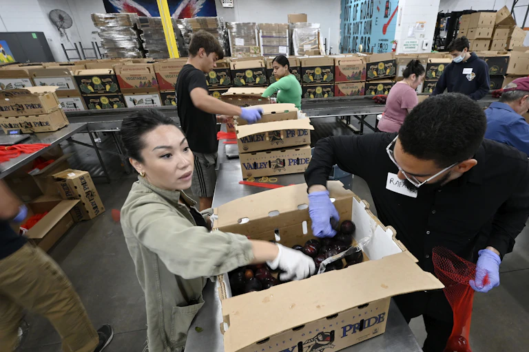 Volunteers sort food at a food bank.