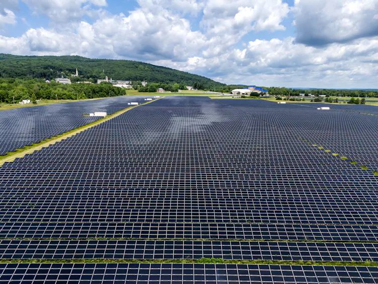 An aerial shot of a large solar farm on a cloudy day.