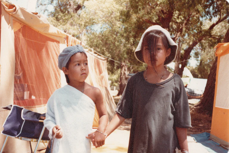 Two children hold hands outdoors