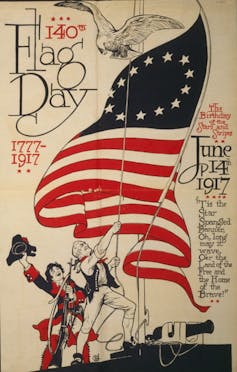 A poster bearing the words “140th Flag Day, 1777–1917” and “The Birthday of the American Flag, June 14, 1917” shows a man raising the American flag, another cheering, and an eagle flying above.