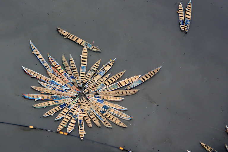 aerial shot of small wooden fishing boats moored up together, grey sea