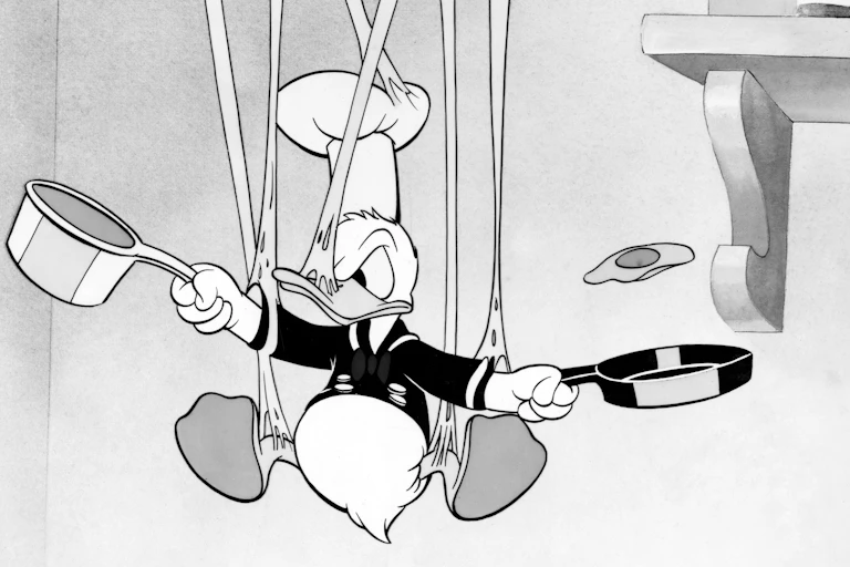 O Pato Donald em preto e branco em uma bagunça enquanto tenta cozinhar.