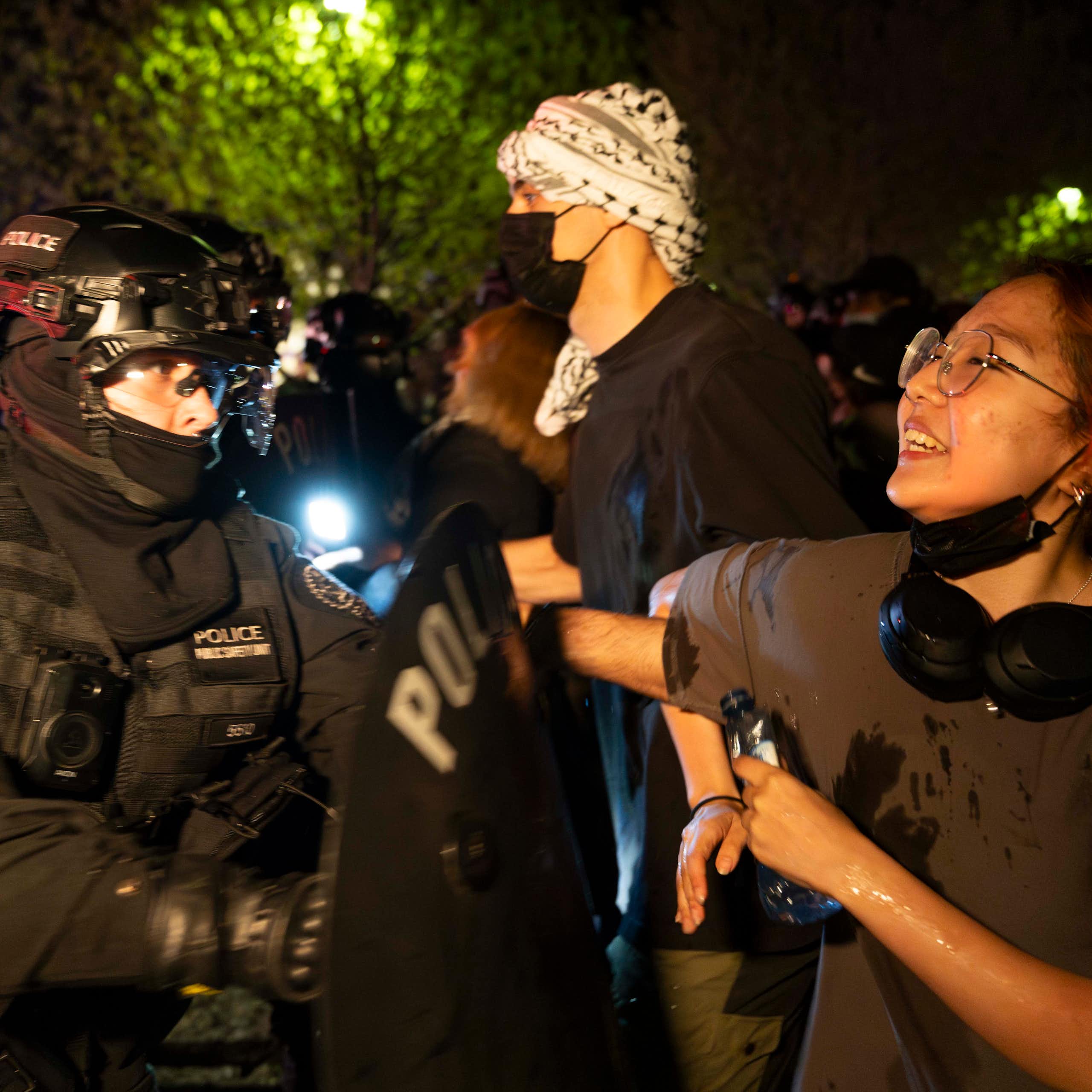 Protesters link arms as police officers try to break them up.
