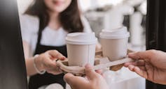 Woman passing tray of coffees to a man