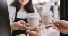 Woman passing tray of coffees to a man