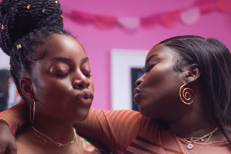 Two women hugging and pouting at each other.