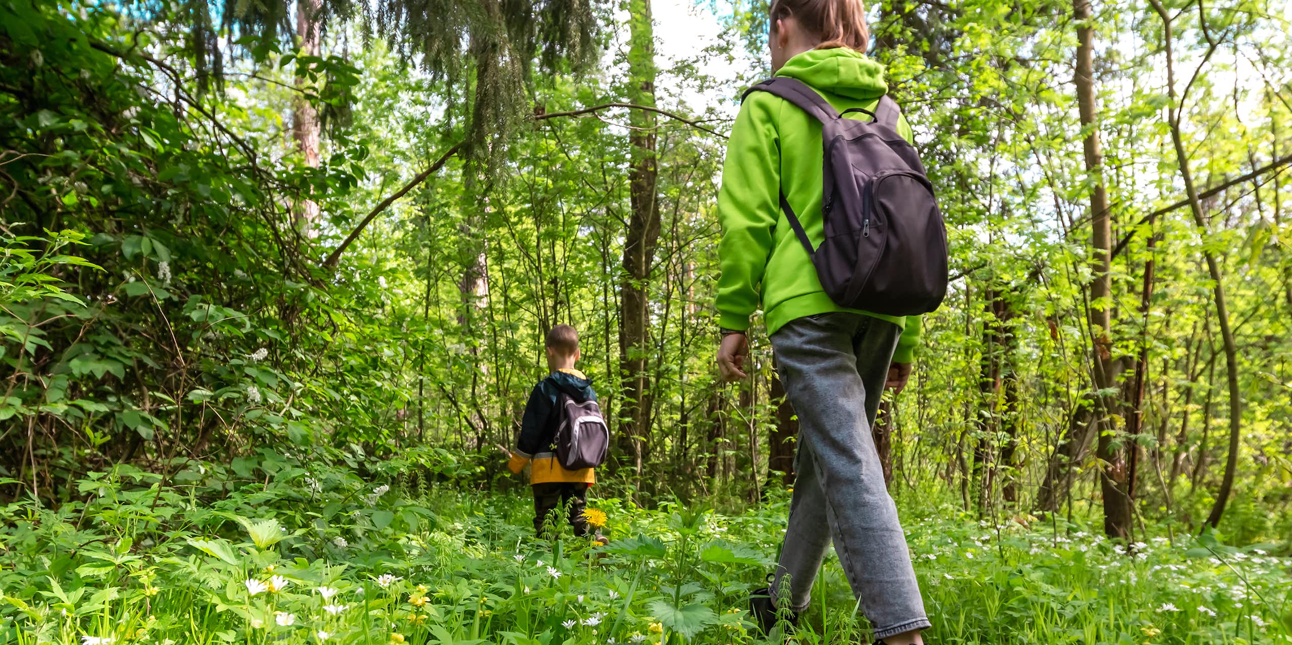 Une femme marchant dans les bois avec un enfant.