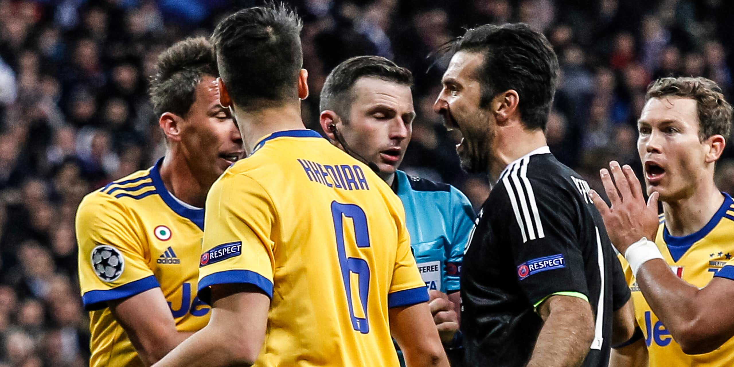 Footballers argue with a referee during a game