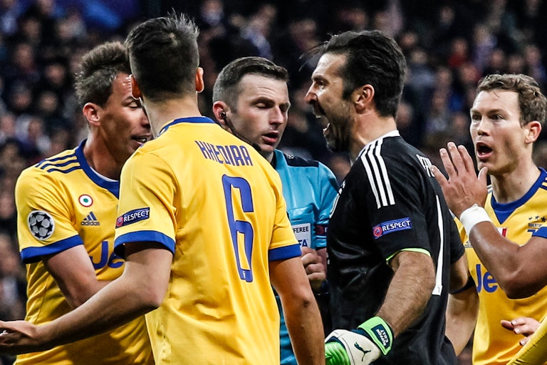 Footballers argue with a referee during a game