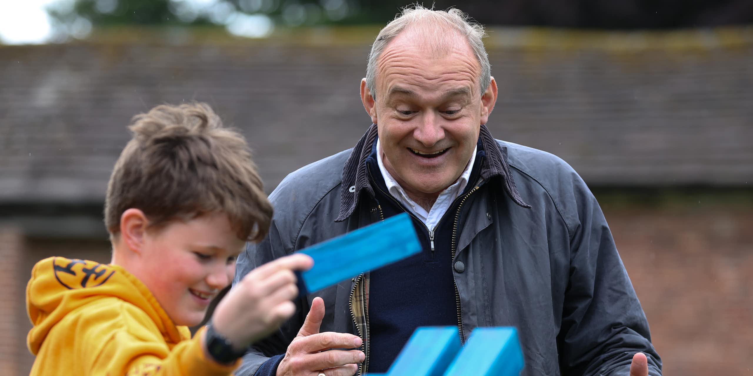 Liberal Democrat leader Ed Davey playing jenga with a child.