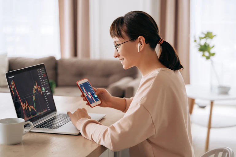 A young woman looking at stock information on a laptop