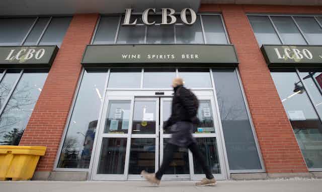 A man walking in front of an LCBO store