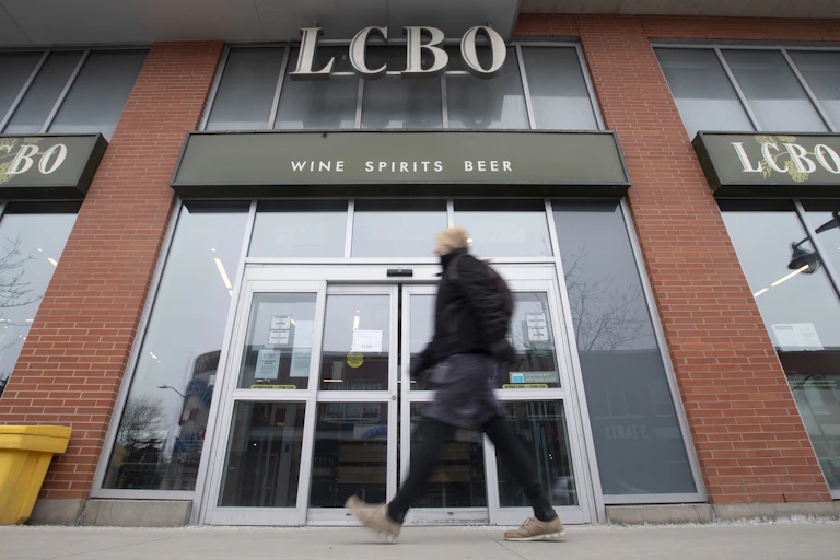 A man walking in front of an LCBO store