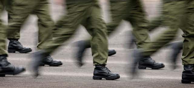 Blurred image of legs running in military style pants and boots