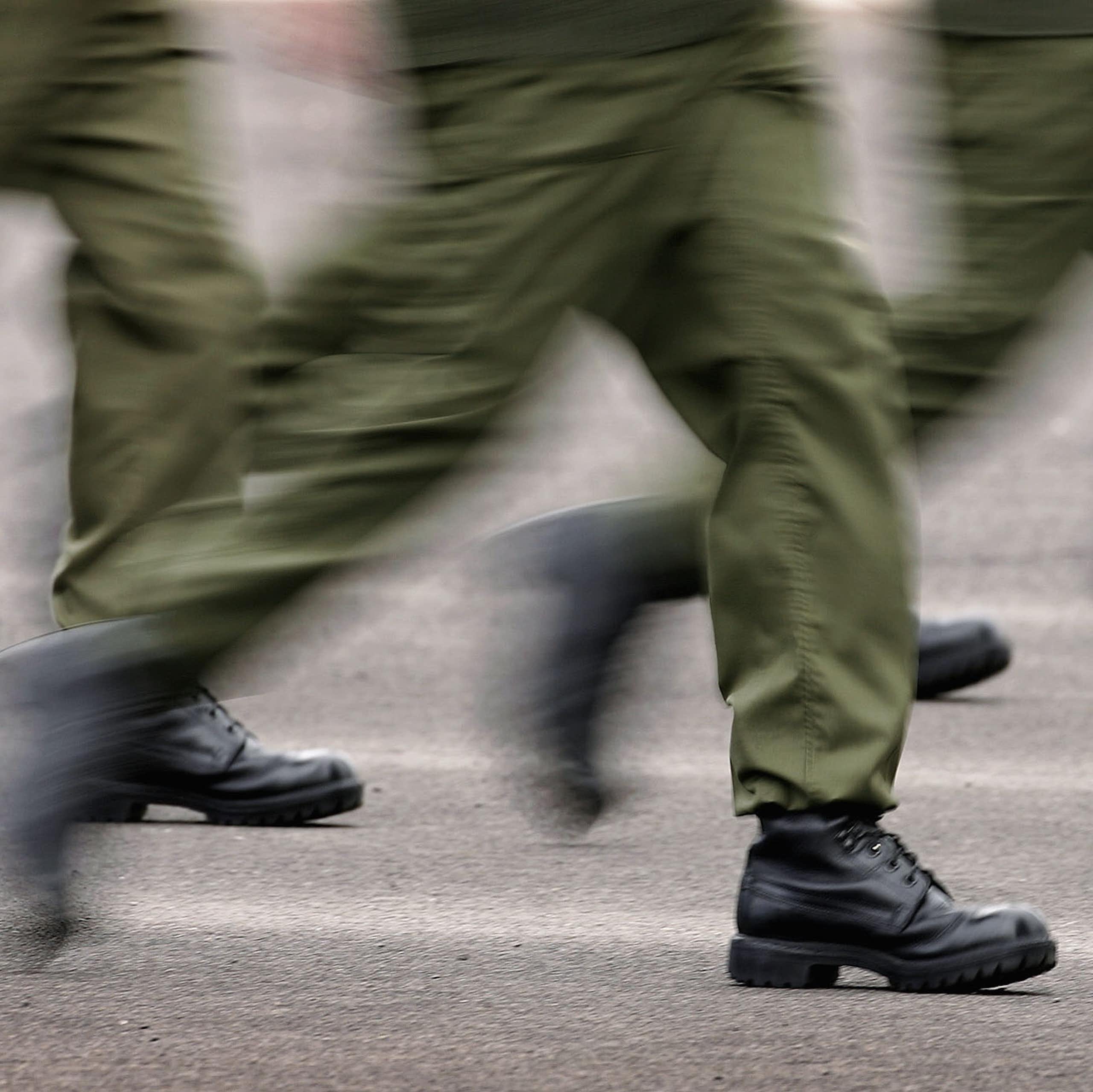 Blurred image of legs running in military style pants and boots