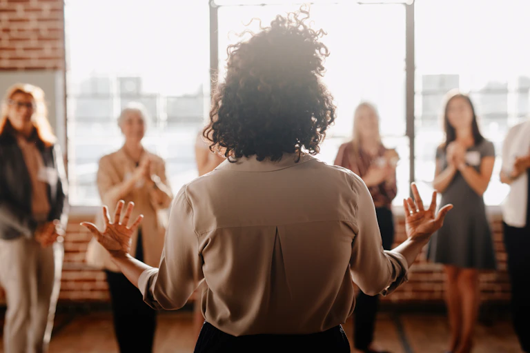 Rear view of a woman speaking to a group of people
