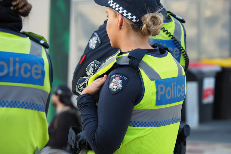 A side profile of a female police officer in uniform flanked by two other officers