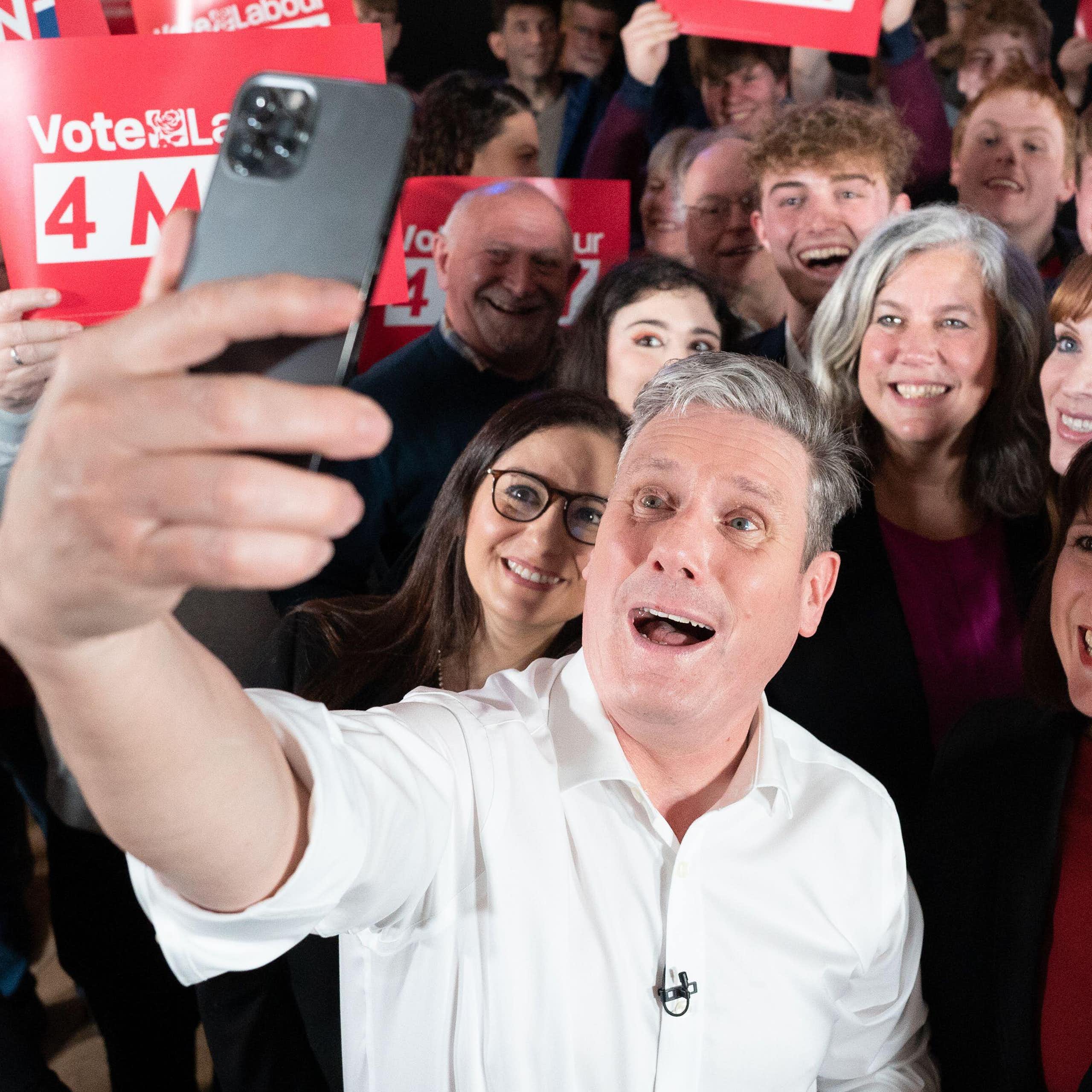 Keir Starmer taking a selfie with members of his cabinet and Labour party activists holding up red 'vote labour' signs