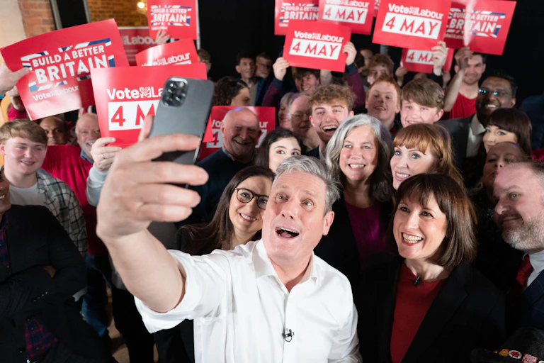 Keir Starmer taking a selfie with members of his cabinet and Labour party activists holding up red 'vote labour' signs