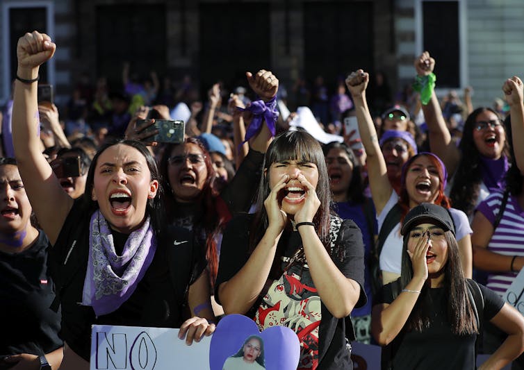 Women shouting and cheering at a march to mark International Women's Day.
