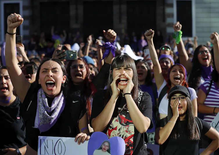 Women shouting and cheering at a march to mark International Women's Day.