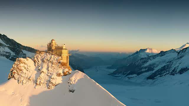 An observatory on the side of a snowy mountain.