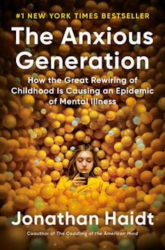 Book cover shows girl on a phone surrounded by small balls on every side of her, the title is The Anxious Generation.