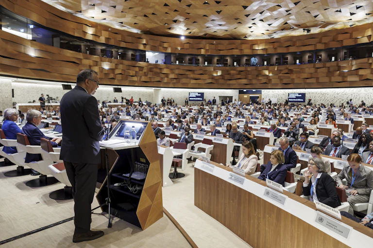 A man standing a podium in front of an assembly.