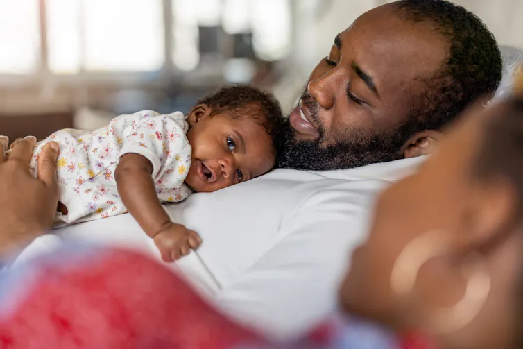 A father with baby on his chest.
