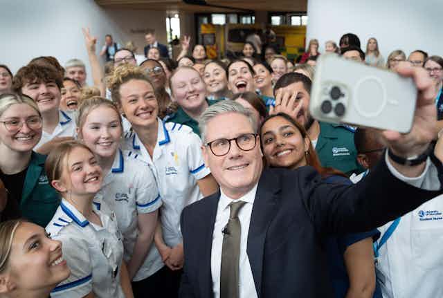 Keir Starmer taking a selfie with student nurses.