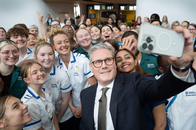 Keir Starmer taking a selfie with student nurses.