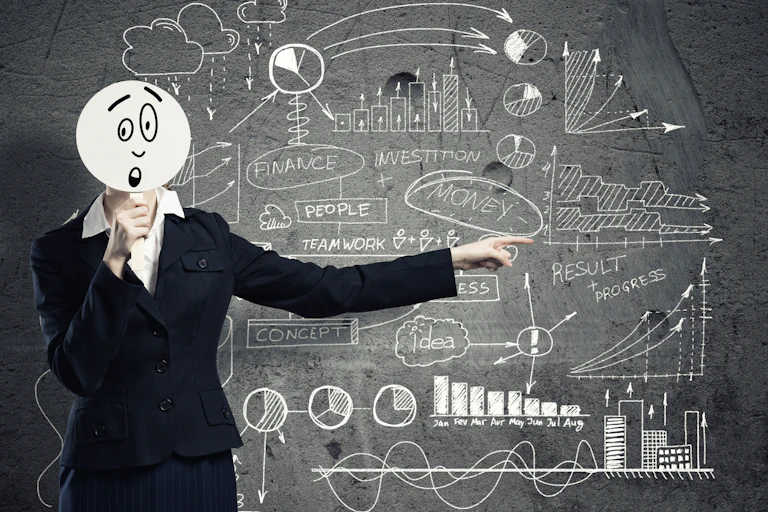 Person with cartoon head in front of complex board of graphs and charts.