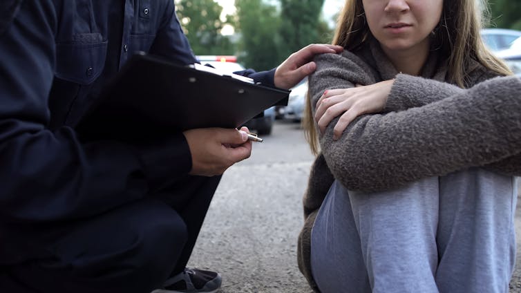 Officer trying to calm down a person – the image doesn't show their faces.