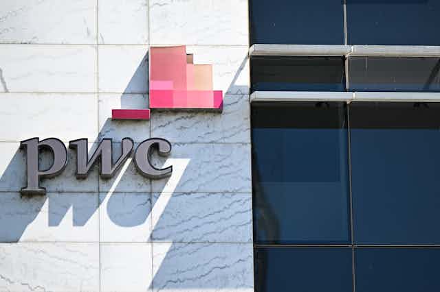 A sign on a building displays the logo of PwC.