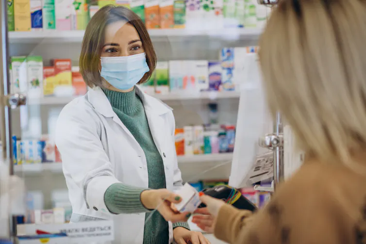 Pharmacist passes medicine to patient