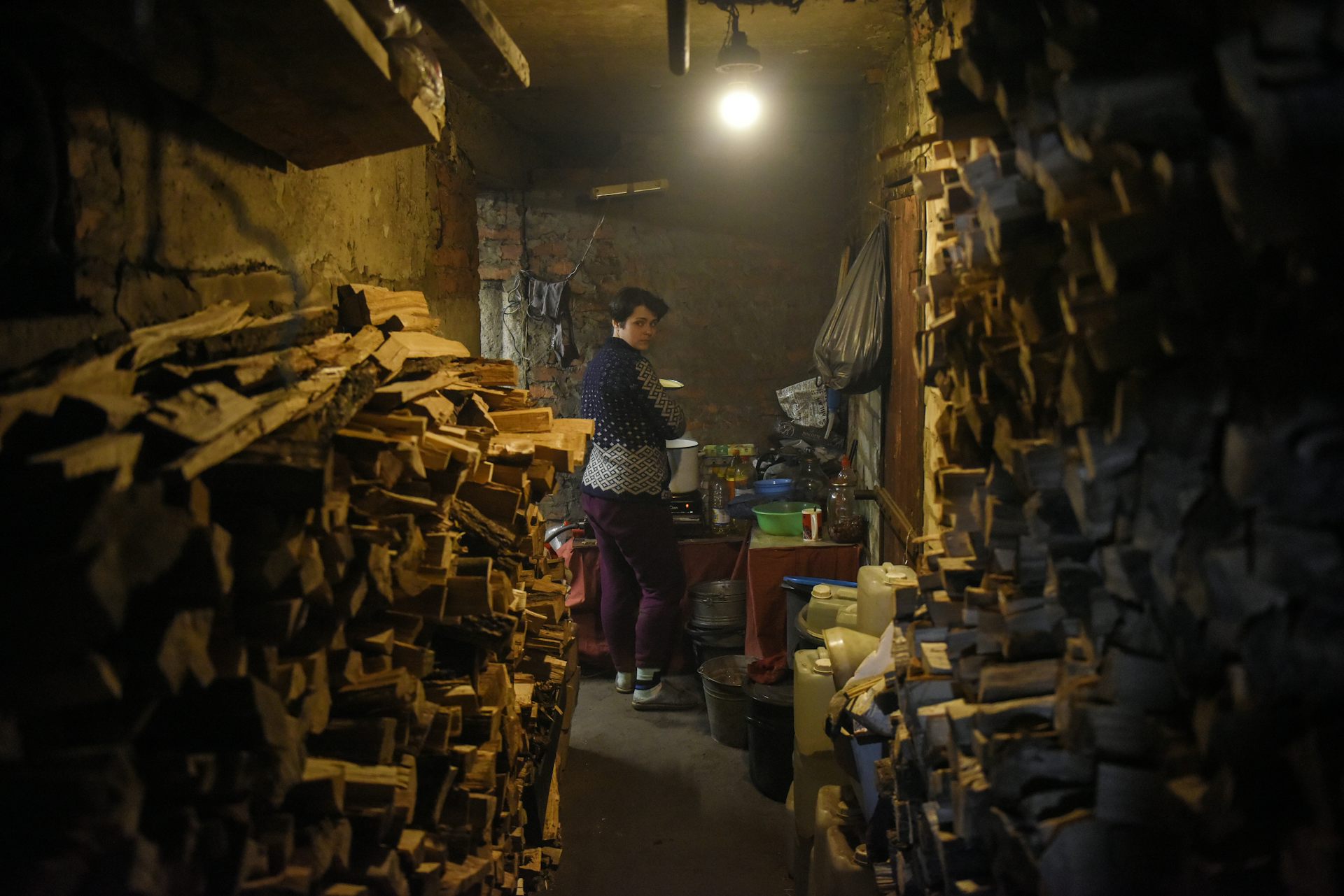A woman cooks a meal in her basement in eastern Ukraine.