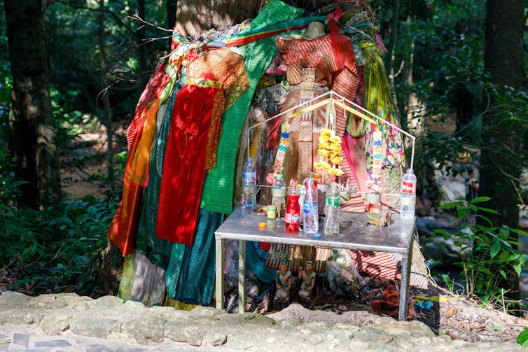 A roadside shrine with drink bottles.