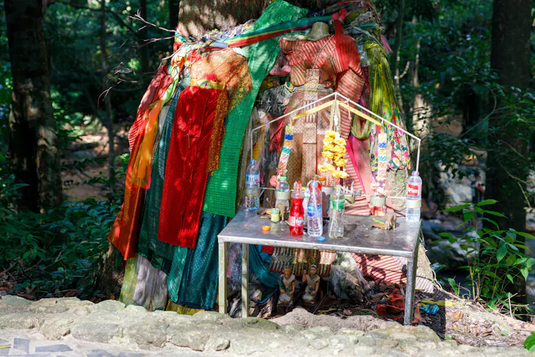 A roadside shrine with drink bottles.