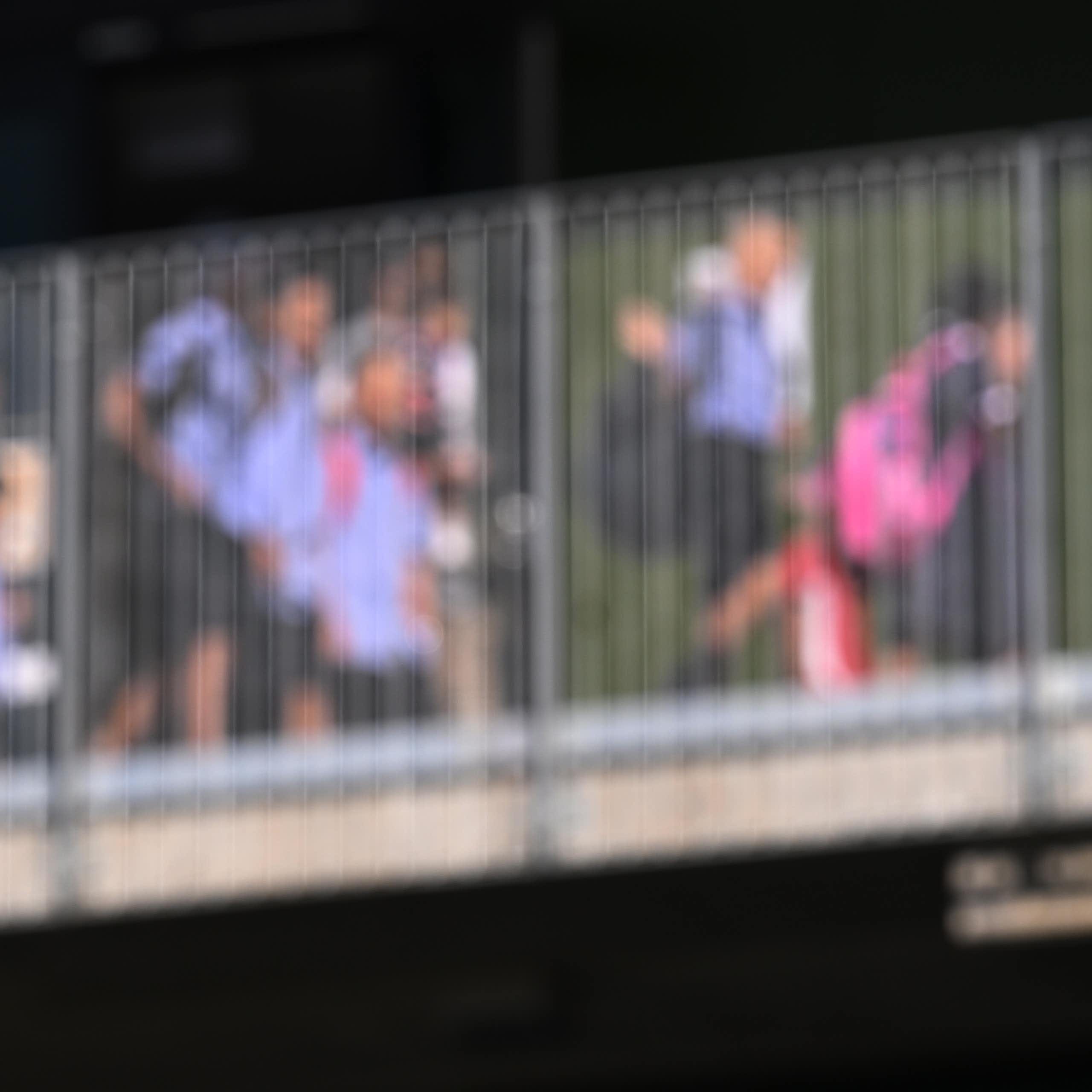 A blurred image of students in uniform walking over a bridge. 